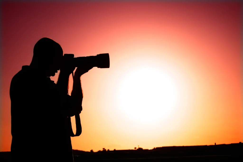 Silueta de fotógrafo al atardecer con exposición decidida a propósito.